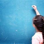 girl drawing on blank chalkboard