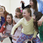group of children with teacher enjoying drama class together