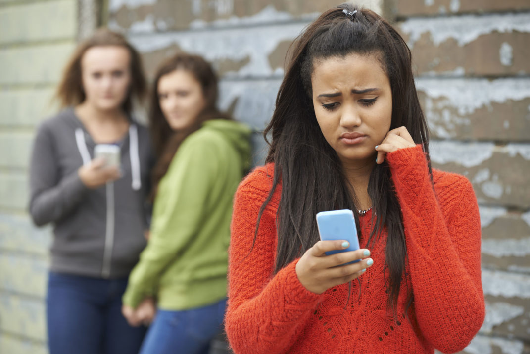 teenage girl being bullied by text message