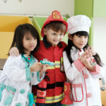 Cute boy and girls playing as fireman, doctor and cook occupatio