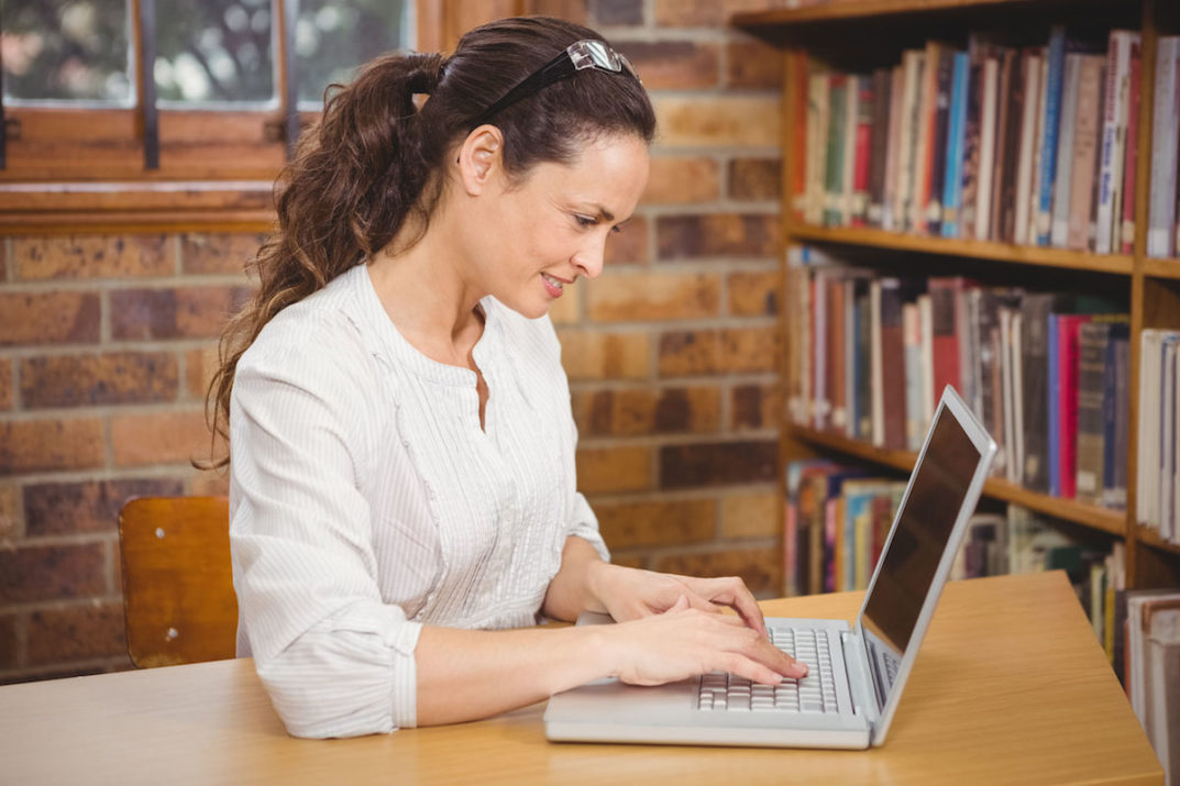 Teacher using laptop in her office at the elementary school