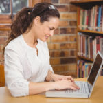 Teacher using laptop in her office at the elementary school