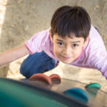 Little boy climbing up brave at playground