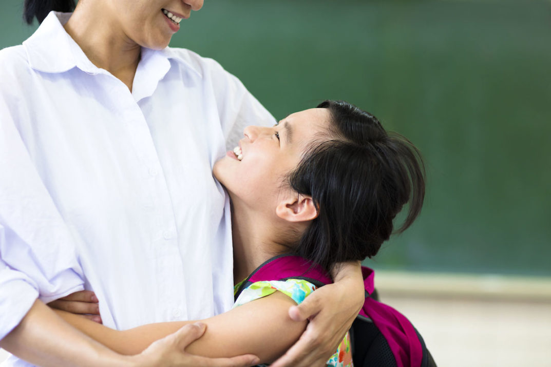 happy Girl hugging her mother in classroom