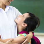 happy Girl hugging her mother in classroom