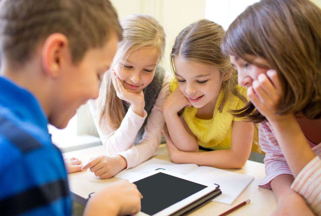 group of school kids with tablet pc in classroom