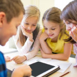 group of school kids with tablet pc in classroom