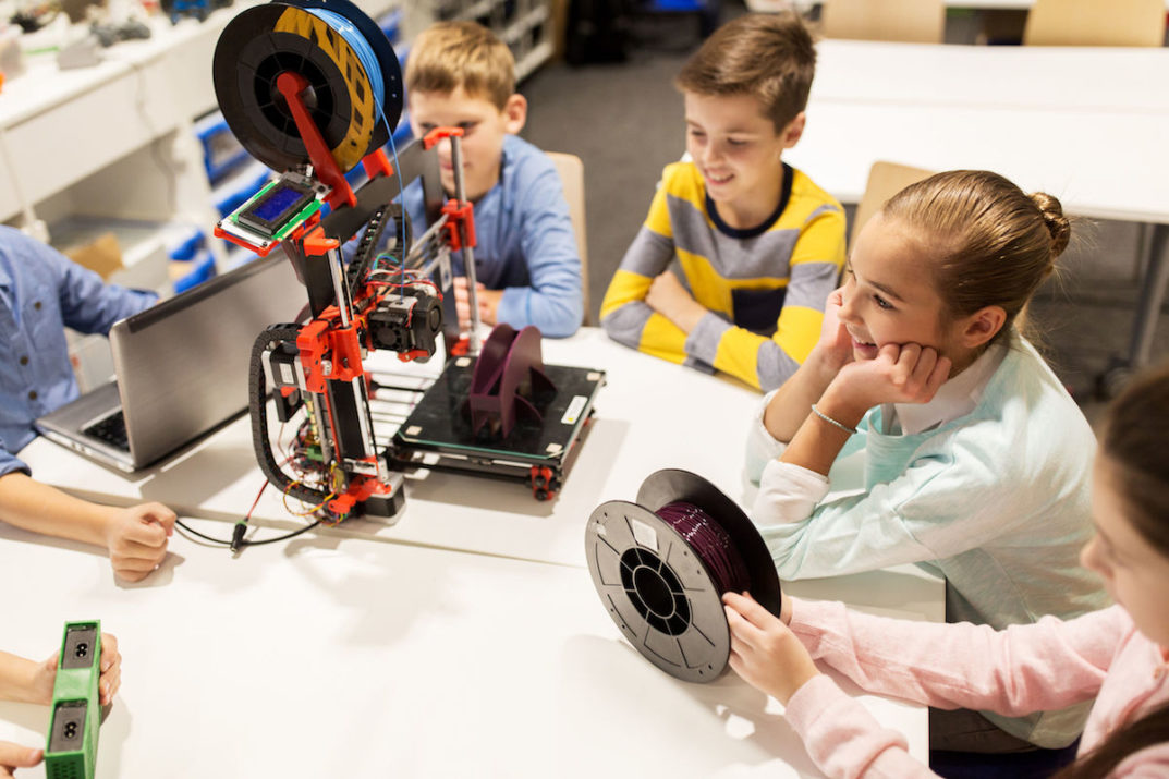 happy children with 3d printer at robotics school