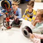 happy children with 3d printer at robotics school