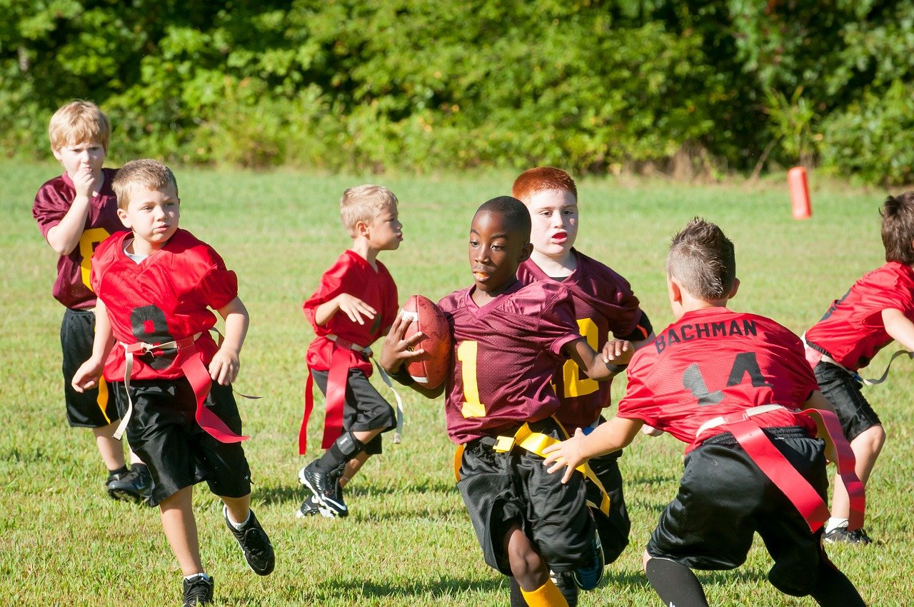 kids playing flag football outside; return to gym class concept