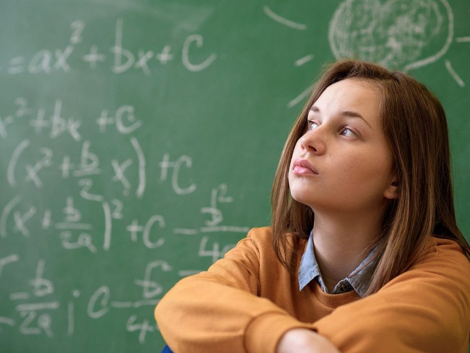 Teenager girl in math class overwhelmed by the math formula. Pressure, Education, Success concept.