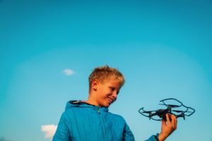 Young boy enjoy playing with drone in nature, kids learn new technology