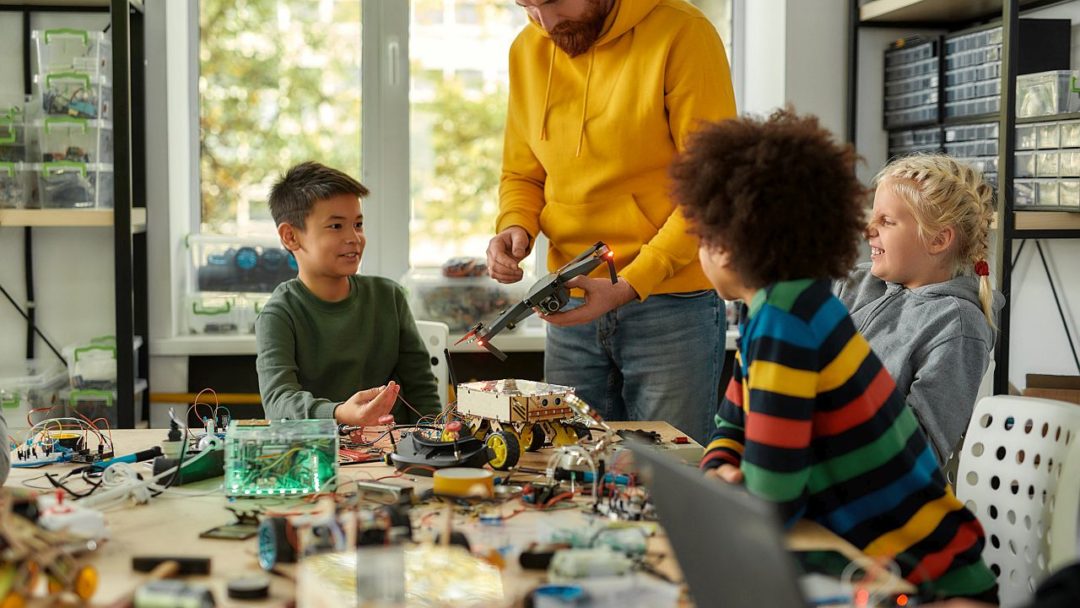 Cropped shot of young creative male teacher explaining for students the principle of quadcopter work. Science and education. Horizontal shot. Web Banner