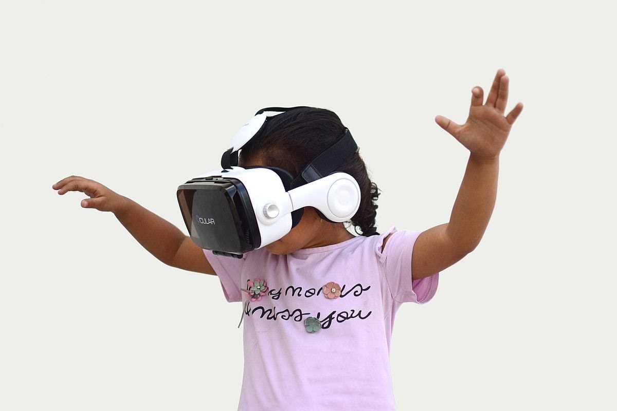 child wearing vr headset and dancing; metaverse learning concept