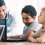 Smart boys and teacher during computer programing class for kids