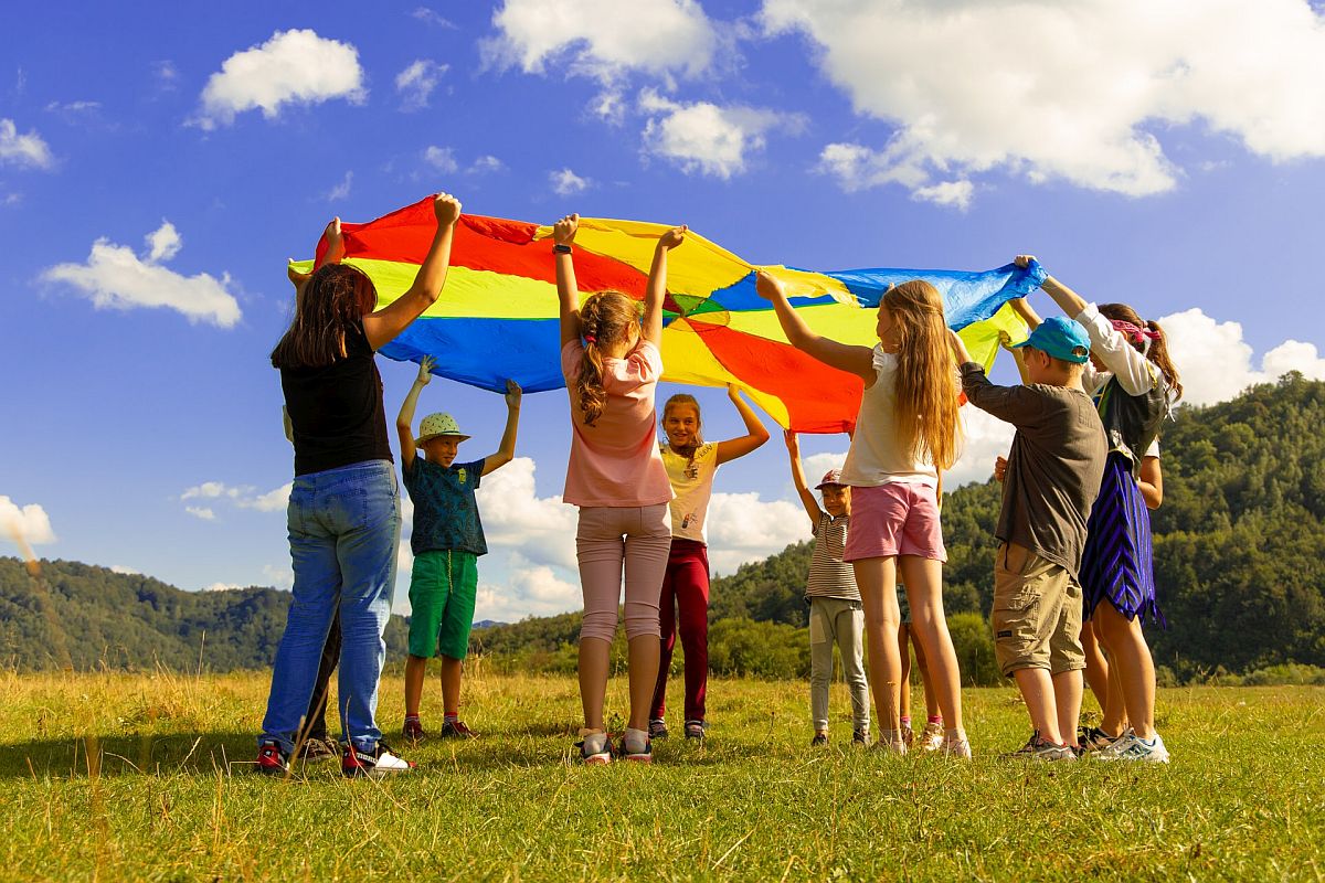 kindergarten class plays with a parachute; group work and social-emotional learning concept