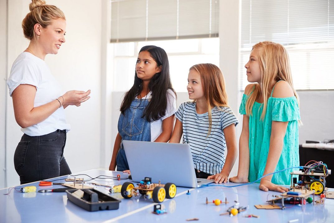 Three Female Students With Teacher Building Robot Vehicle; careers lessons plans concept