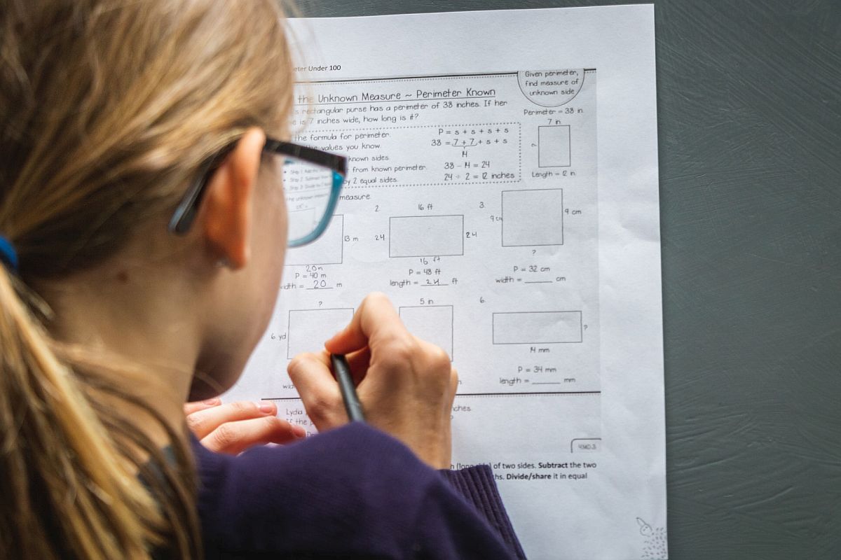 young schoolgirl doing math homework; math real-world use concept