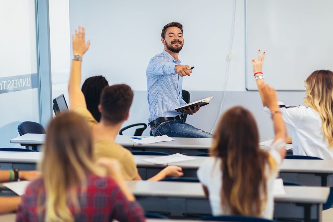 Group of students raising hands in class; ; time-saving hacks for teachers concept