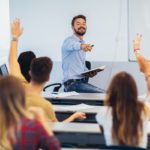 Group of students raising hands in class; ; time-saving hacks for teachers concept