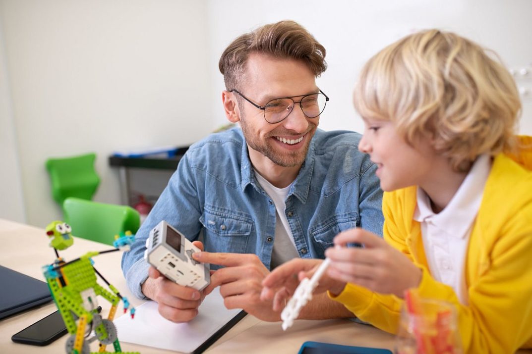 Teacher smiling with young student; paraeducators and teachers concept