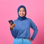 Smiling girl holding cell phone; voting lesson plans concept