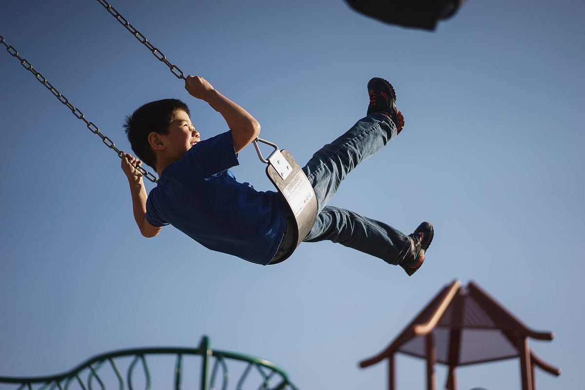 Happy child on swing; neurodiverse students concept