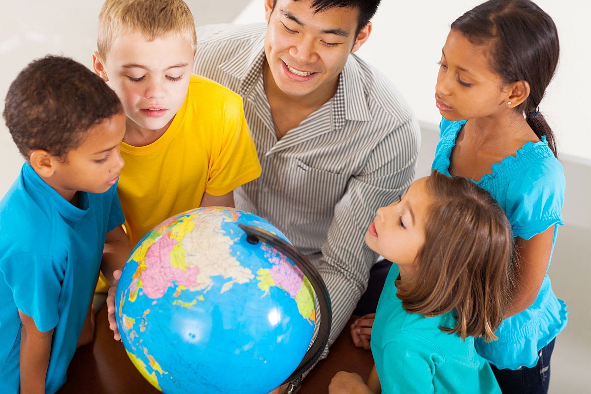 Adult man and children looking at globe; English Language Learners concept
