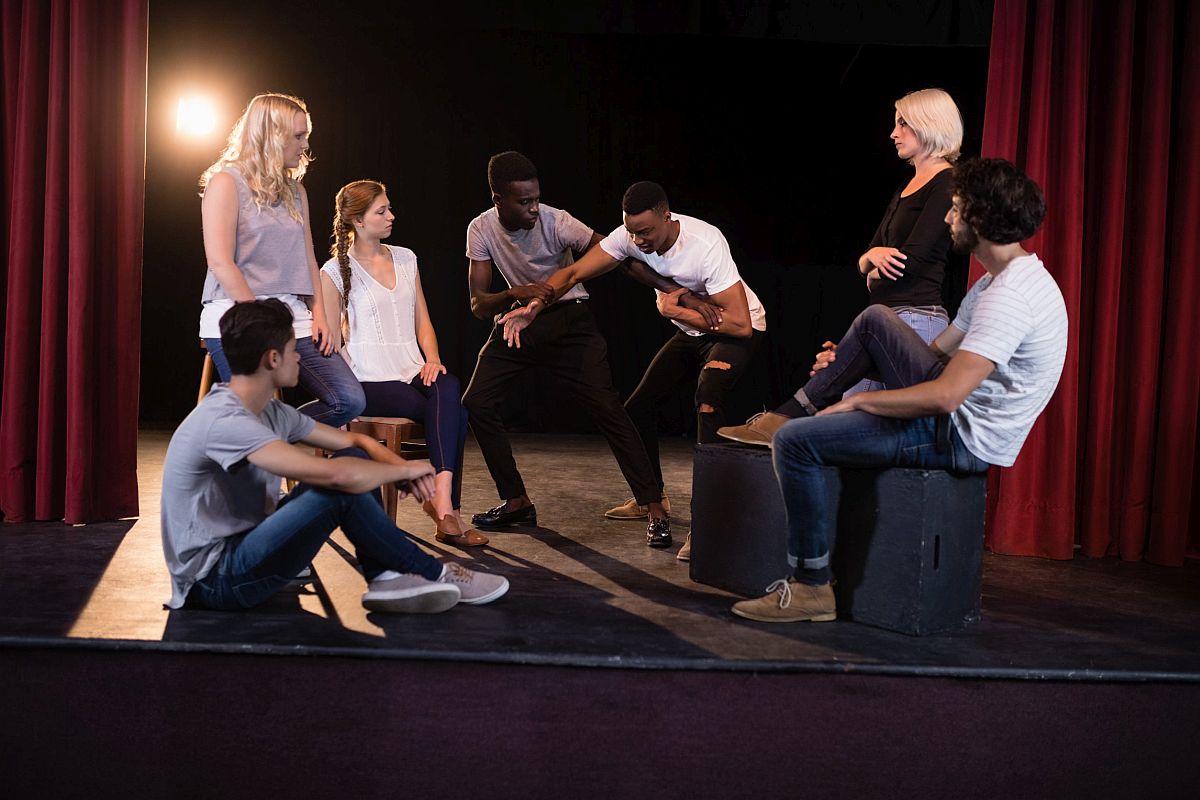 Group of people on stage in a rehearsal; improve social emotional skills concept