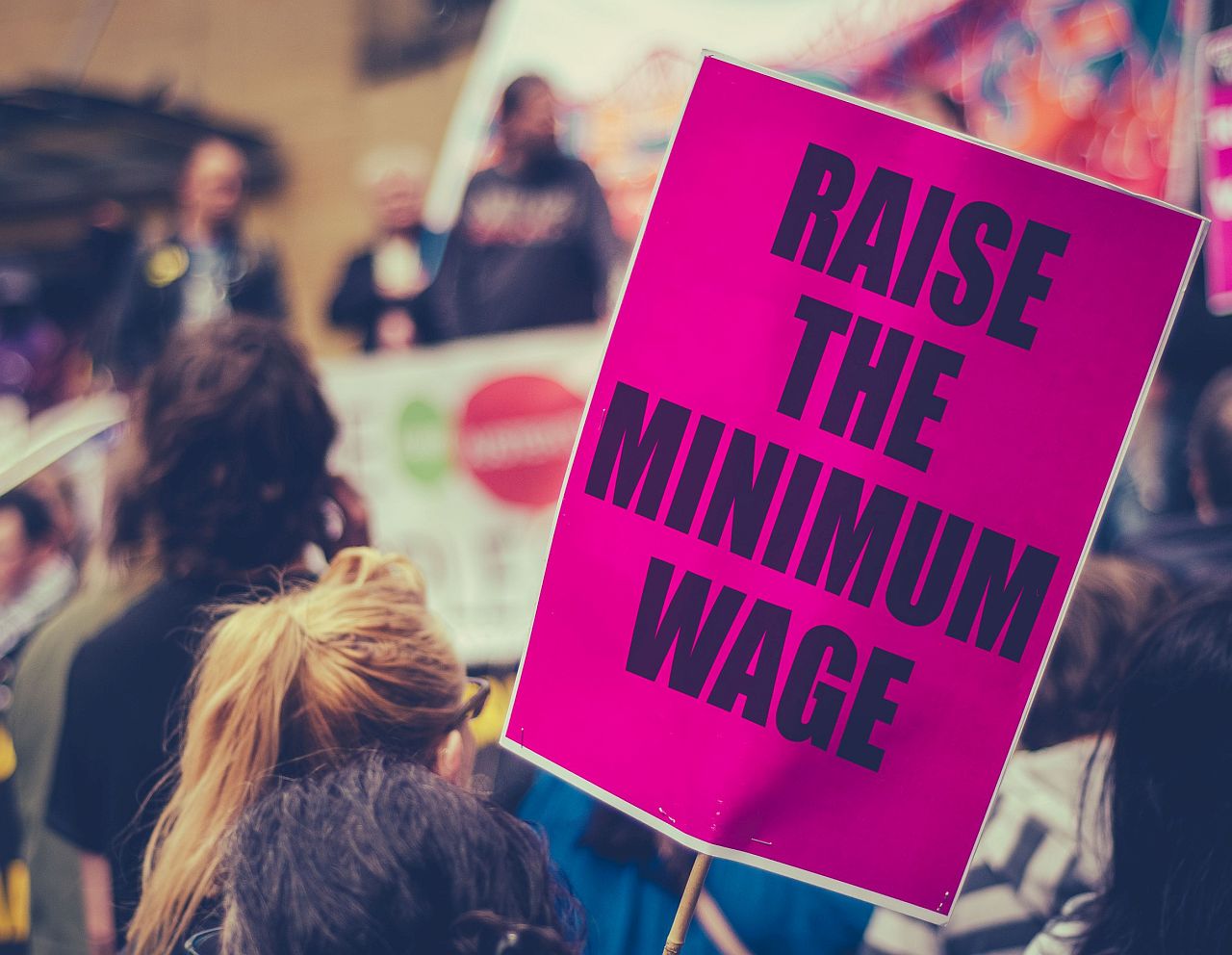 pink sign reading raise the minimum wage; labor history lesson plans concept