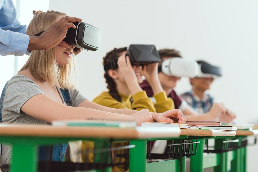 Students using virtual reality headset in class; virtual field trips concept