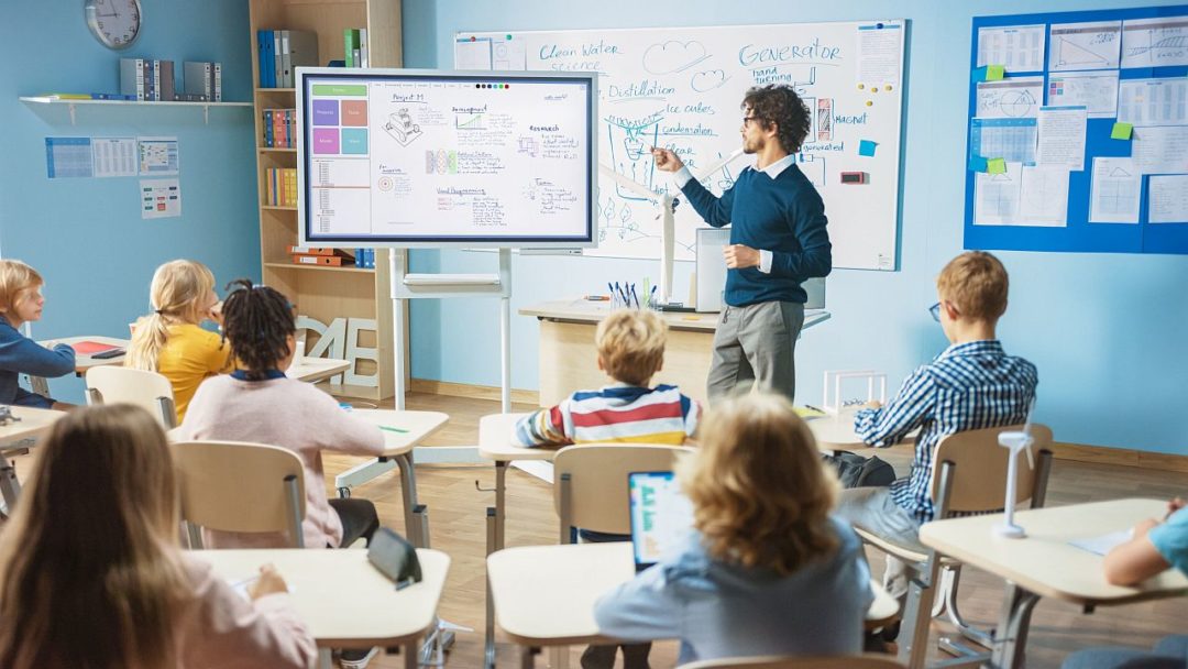 Teacher in front of classroom; edtech tools concept