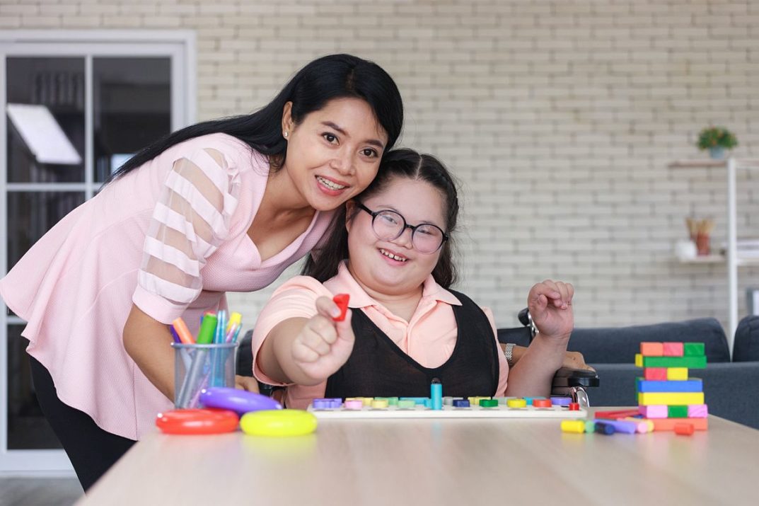 Woman helping student; paraprofessionals in education concept.