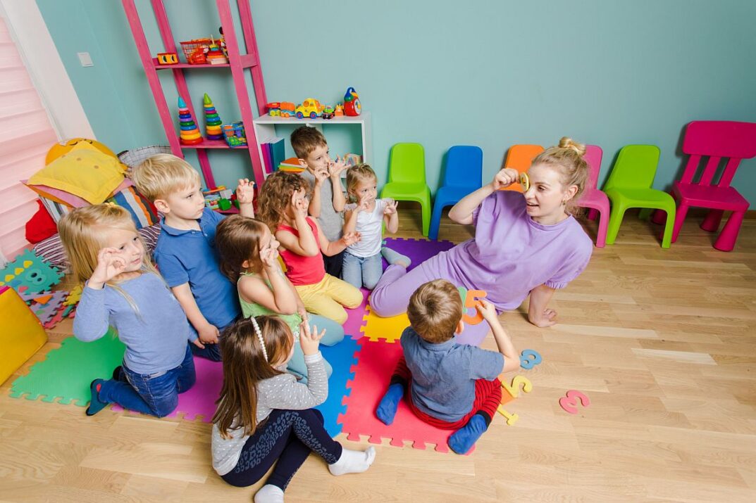 Young students playing numbers games with teacher; make math fun concept