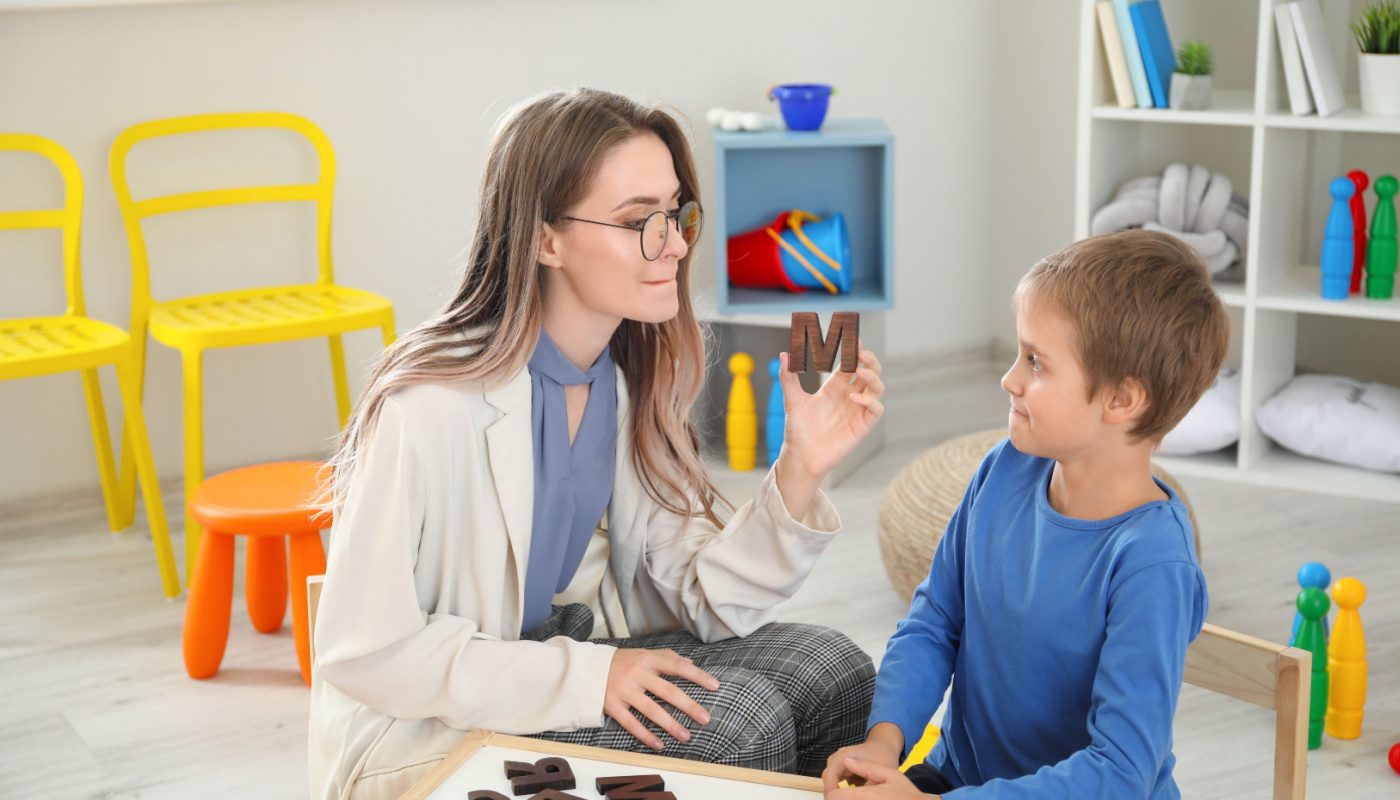 Speech therapist working with little boy; speech therapists concept