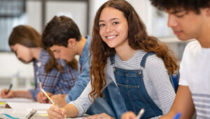 Smiling student sitting in a row of other students