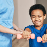 Physical therapist working with student; physical therapists role concept