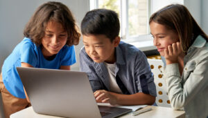 Three children working on laptop together