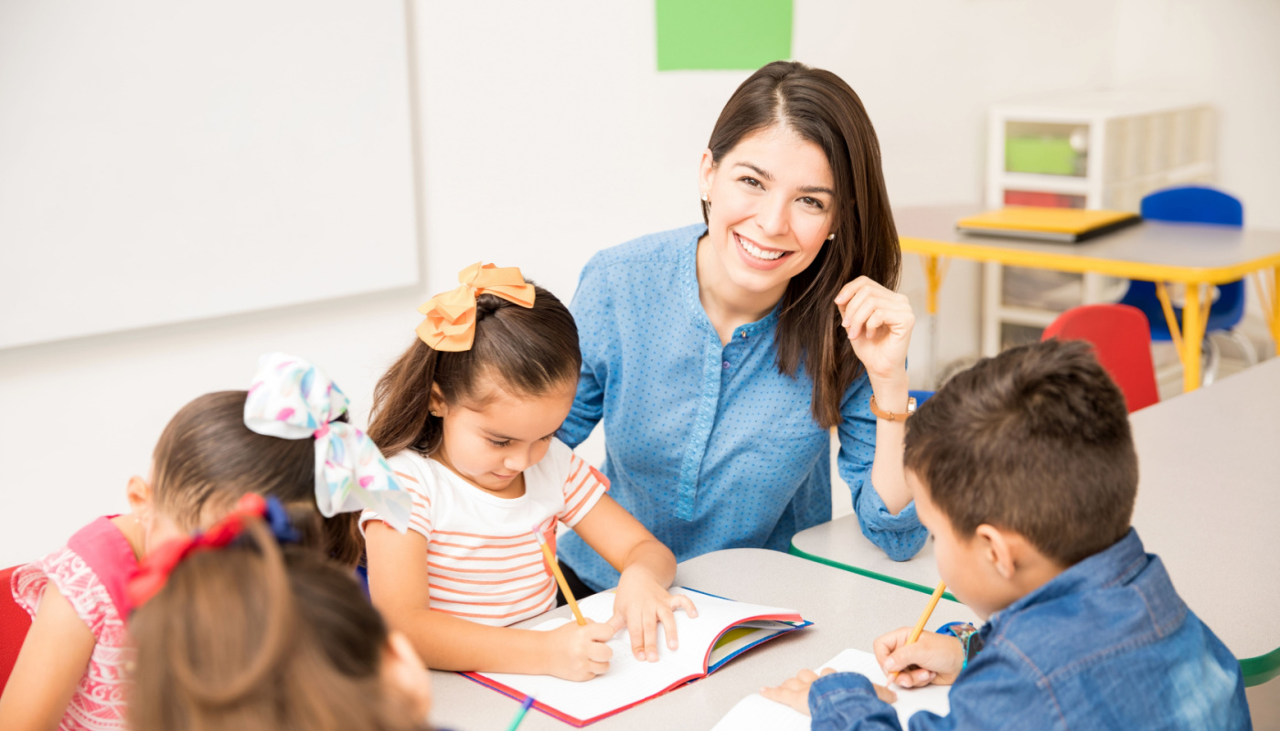 Smiling teacher sitting with young students; Four-Day School Week concept