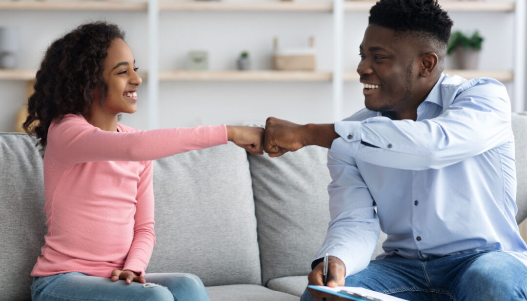 School counselor fist-bumping student; career counselors concept