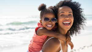 Mother and daughter having fun on the beach; year-round school concept